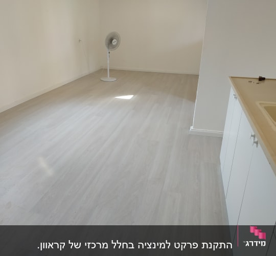 רצפת פרקט בהירה בחדר ריק עם מאוורר